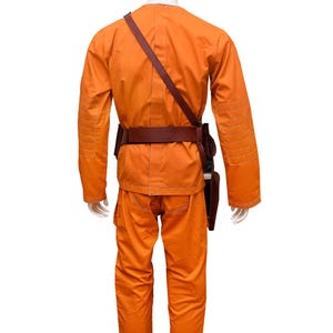 This listing features a high-quality, screen-accurate Star Wars Rebel Pilot/Prisoner Costume Replica, perfect for cosplayers, collectors, and fans. The outfit includes a bright orange flight suit with detailed stitching, padded knee panels, and large utility pockets for an authentic look. A brown leather belt with holsters and an adjustable cross-body strap completes the ensemble, making it a must-have for conventions, cosplay Mandalorian events, and Star Wars enthusiasts.  Halloween, Comic-Con.