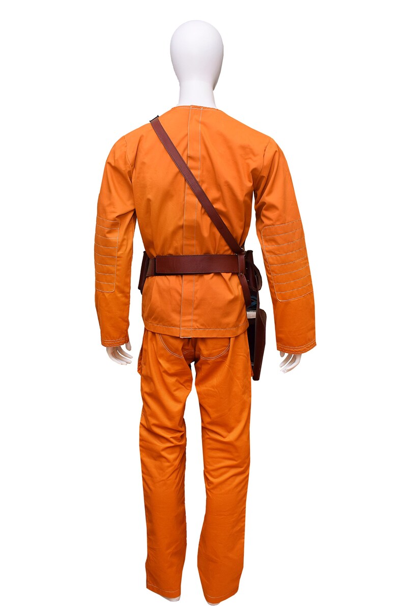 This listing features a high-quality, screen-accurate Star Wars Rebel Pilot/Prisoner Costume Replica, perfect for cosplayers, collectors, and fans. The outfit includes a bright orange flight suit with detailed stitching, padded knee panels, and large utility pockets for an authentic look. A brown leather belt with holsters and an adjustable cross-body strap completes the ensemble, making it a must-have for conventions, cosplay Mandalorian events, and Star Wars enthusiasts.  Halloween, Comic-Con.