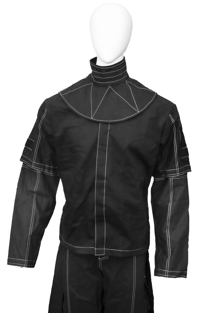 May include: A black long-sleeved shirt with a high collar and white stitching. The shirt has a geometric design on the collar and sleeves.