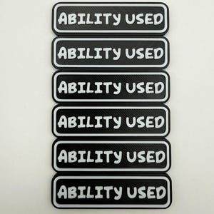 May include: Six rectangular black patches with white borders and the white text "ABILITY USED" in a bold, rounded font. Each patch features a raised, textured surface with a consistent design, arranged in a vertical stack on a plain background.
