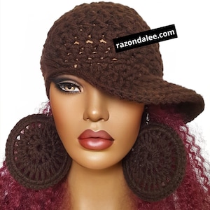 May include: A dark brown crocheted hat with a brim and matching large circular crocheted earrings. The hat features a textured pattern and a black rectangular tag with the white text razondalee.com attached to the side.
