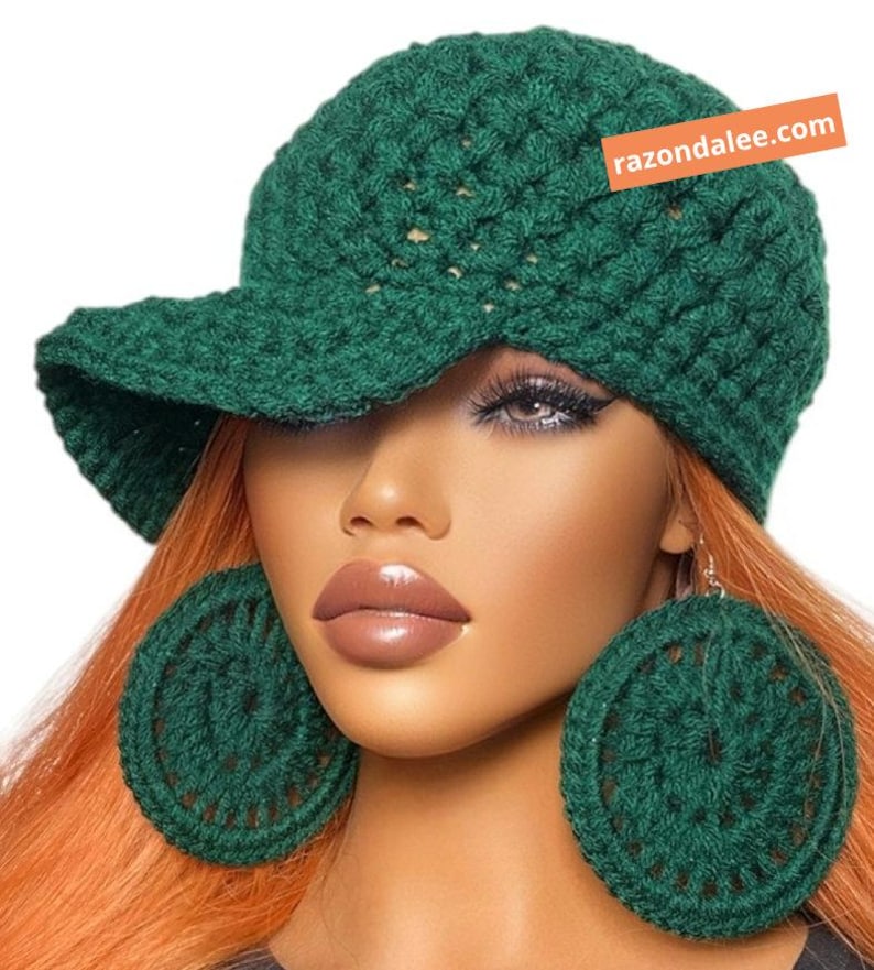 May include: A dark green crocheted baseball cap with a textured stitch pattern and a matching pair of large, circular crocheted earrings. The cap features an orange rectangular tag with the white text razondalee.com.