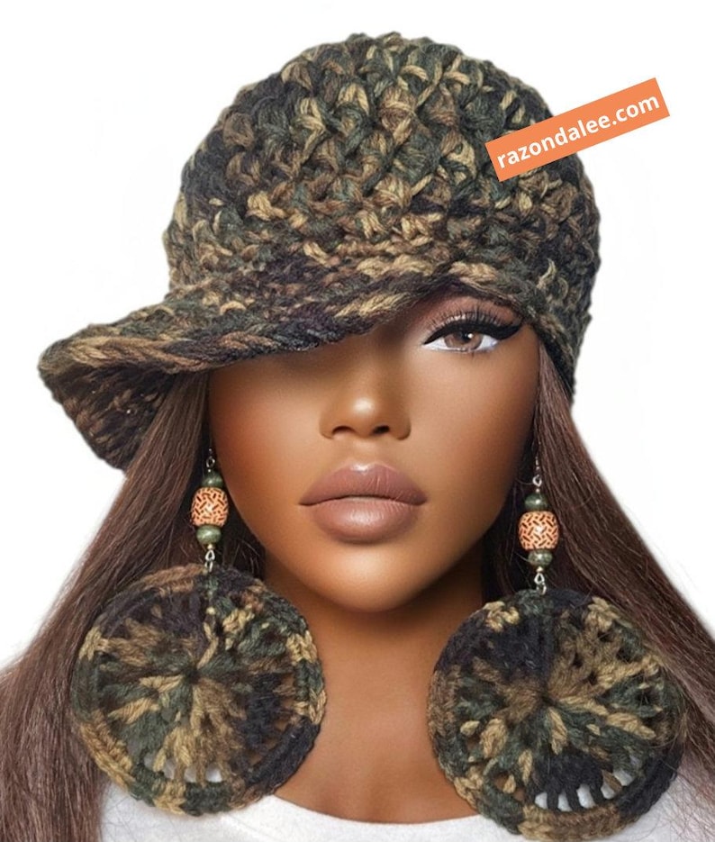 May include: A camouflage-patterned crochet hat with a brim and matching large circular crochet earrings featuring wooden beads. The hat includes an orange rectangular tag with the white text razondalee.com.