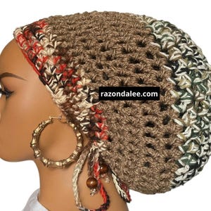 May include: A slouchy crochet beanie in shades of brown, red, cream, and green, featuring an open-weave pattern, dangling yarn ties with wooden beads, and the text razondalee.com. The hat is worn on a mannequin head with large gold hoop earrings.