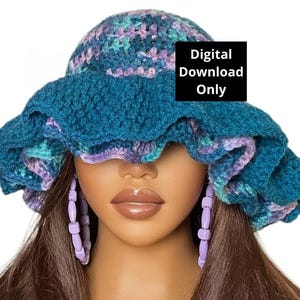 Op de afbeelding: Een teal blauwe gebreide bucket hat met een gerimpelde rand en paarse en groene accenten. De hoed zit op een mannequin met lang bruin haar en paarse kralen oorbellen. Alleen digitale download.