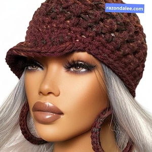 May include: A burgundy crochet hat with a small brim. The hat is paired with matching burgundy hoop earrings. The website razondalee.com is visible in the image.