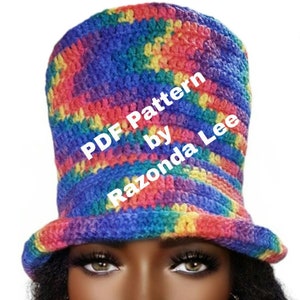 May include: A rainbow crochet hat with a wide brim. The hat is being worn by a person. The text "PDF Pattern by Razonda Lee" is superimposed on the hat.