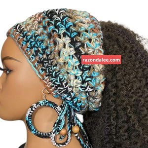 May include: A crocheted head wrap featuring a variegated pattern of black, turquoise, tan, and white yarn. The accessory includes matching circular hoop earrings wrapped in the same yarn with dangling wooden beads. The text razondalee.com is visible.