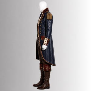 Puede incluir: Un abrigo largo azul marino con charreteras doradas, botones de lat&oacute;n y pu&ntilde;os rojos, sobre un chaleco color crema y pantalones oscuros. El conjunto incluye botas altas de cuero marr&oacute;n con estrellas doradas decorativas en las ca&ntilde;as.