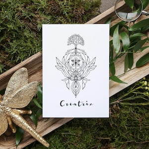 May include: A white card with a black line art design featuring a tree, floral elements, and the word "Creatrix." The card is on a wooden tray with a gold dragonfly, moss, and greenery.