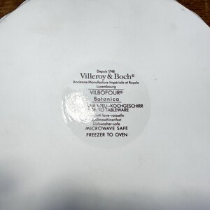 May include: A white ceramic dish base featuring a Villeroy & Boch stamp. The text reads: Depuis 1748, Villeroy & Boch, Ancienne Manufacture Imp&eacute;riale et Royale, Luxembourg, VILBOFOUR, Botanica, OVEN TO TABLEWARE, DISHWASHER SAFE, MICROWAVE SAFE, FREEZER TO OVEN.