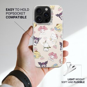Puede incluir: Funda transparente para tel&eacute;fono con un patr&oacute;n repetido de personajes de dibujos animados de colores. La funda se sostiene en una mano, con el texto "EASY TO HOLD POPSOCKET COMPATIBLE" visible. La funda se describe como "LIGHT WEIGHT SOFT AND FLEXIBLE".