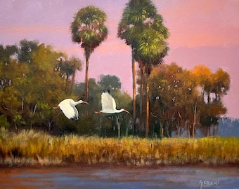 May include: A painting of two white ibis birds flying over a marsh with palm trees in the background. The sky is a soft pink and purple color.