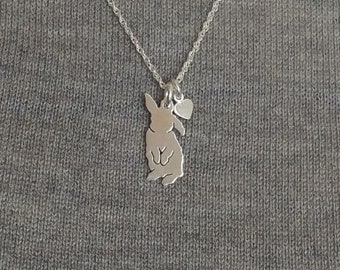 May include: A silver chain necklace with a small rabbit charm and a heart charm.