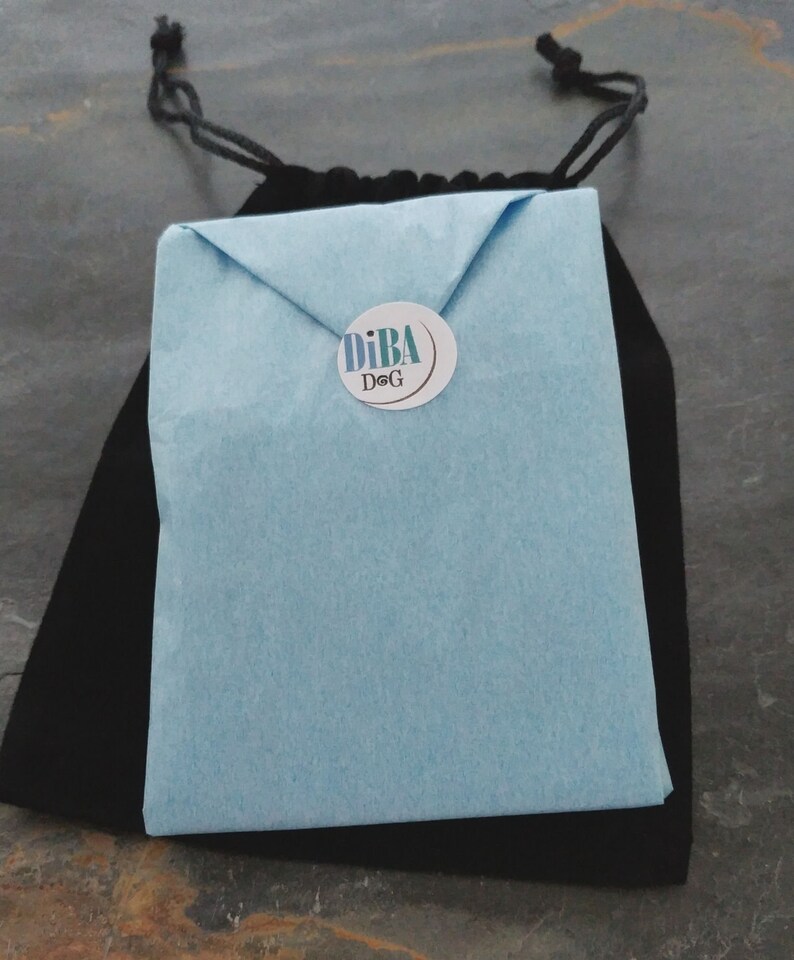 May include: A light blue envelope with a white circle sticker that says "DiBA DoG" in black text.