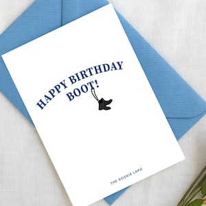 Può includere: Un biglietto di auguri bianco con il testo blu navy "HAPPY BIRTHDAY BOOT!" e un'illustrazione di stivale. Il biglietto è all'interno di una busta azzurra, con lavanda e verde a destra. Le parole "DIGITAL DOWNLOAD" sono nell'angolo in alto a destra.