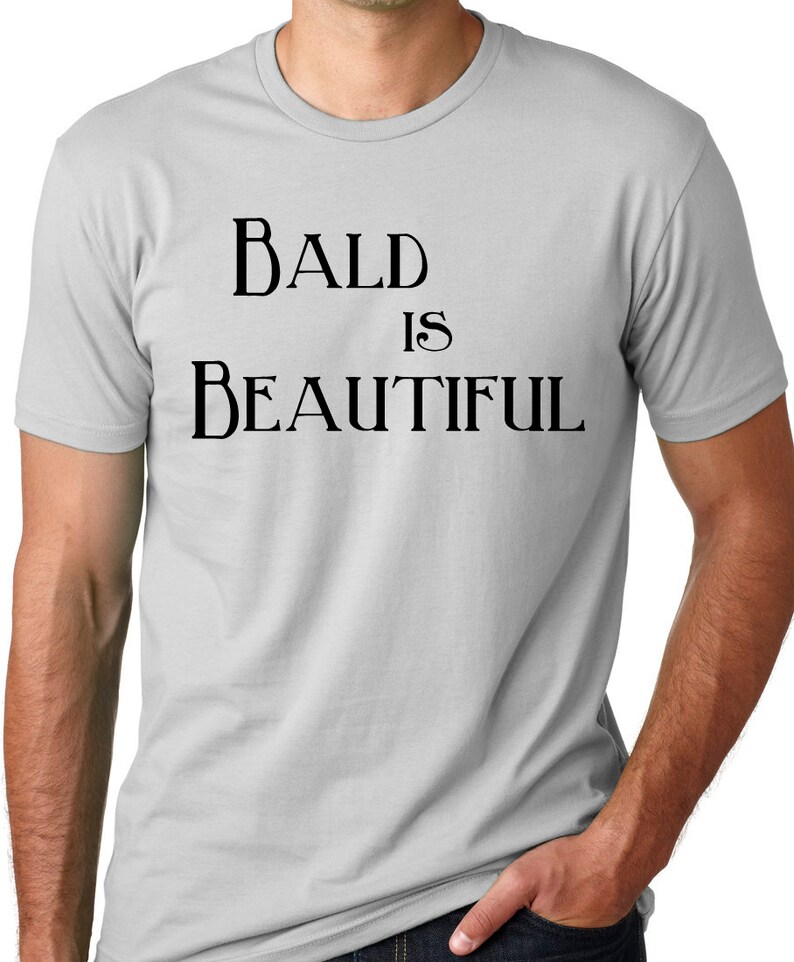 May include: A gray t-shirt with the text "BALD IS BEAUTIFUL" printed in black.
