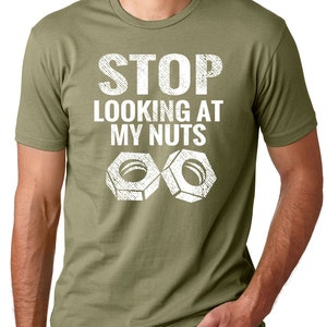 May include: A green t-shirt with the text "STOP LOOKING AT MY NUTS" in white with two white nuts below the text.