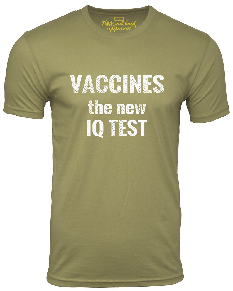 Puede incluir: Una camiseta verde caqui con el texto "Vaccines the new IQ TEST" impreso en blanco.