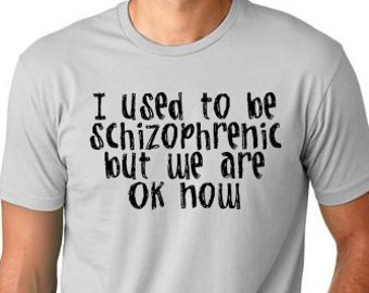 May include: A gray t-shirt with the text "I used to be schizophrenic but we are ok now" printed in black.