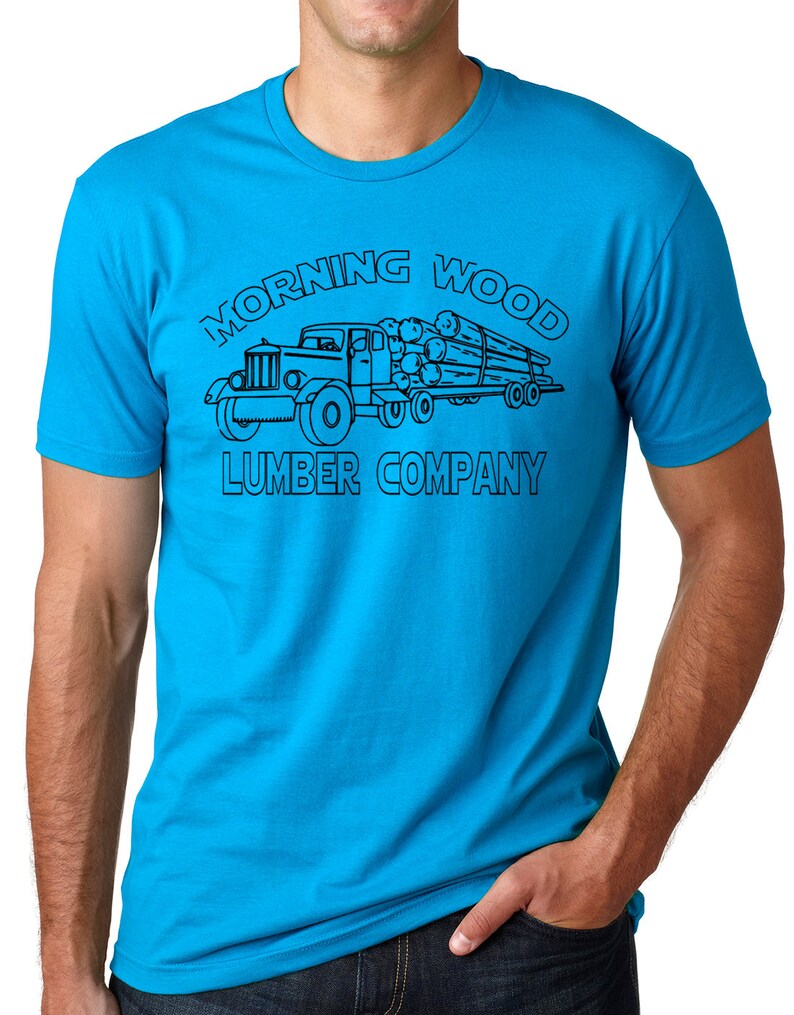 May include: A turquoise t-shirt featuring a black graphic of a vintage lumber truck carrying logs. The text "MORNING WOOD LUMBER COMPANY" is arched above and below the truck illustration.
