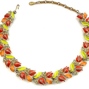May include: A gold tone necklace with a design of orange, red, and yellow enamel leaves and flowers. The necklace has a clasp closure.