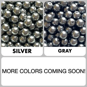 May include: A collection of round, metallic silver beads and dark gray beads, each featuring a central hole for threading. The image includes the text labels SILVER and GRAY, along with the text MORE COLORS COMING SOON!