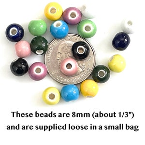 8mm colorful glazed ceramic beads are scattered over a US quarter to show size.  Underneath the photo is text stating that the beads are 8mm, about one third inch in diameter, and that they are supplied loose in a bag.