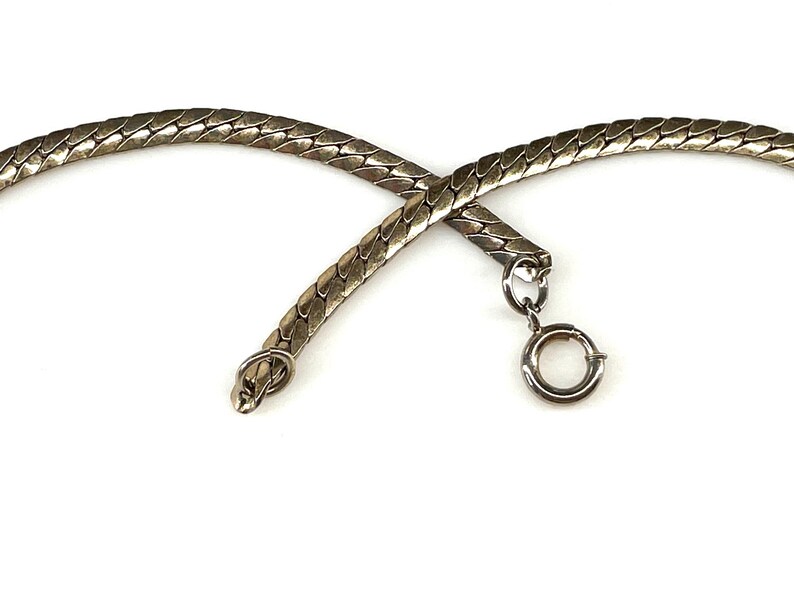 May include: A silver snake chain necklace with a lobster clasp closure.