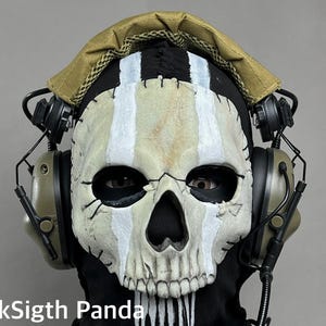 May include: A skull mask with white stripes and black accents, worn with a black hood and tan headphones. The mask has a realistic, weathered appearance. The text "DarkSigth Panda" is visible at the bottom.