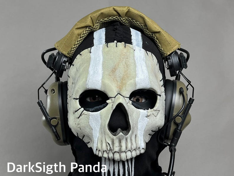 May include: A skull mask with white stripes and black accents, worn with a black hood and tan headphones. The mask has a realistic, weathered appearance. The text "DarkSigth Panda" is visible at the bottom.