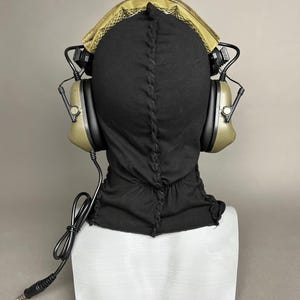 May include: Black balaclava with olive green headphones and a gold-colored mesh top. The headphones have black accents and a connecting wire. The text "DarkSigth Panda" is at the bottom of the image.