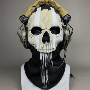 May include: A skull mask with a black hood and white vertical stripes. The mask has a beige and white color scheme with black eye sockets and a black nose. The mask is adorned with a headset and a microphone. The text "DarkSigth Panda" is at the bottom.