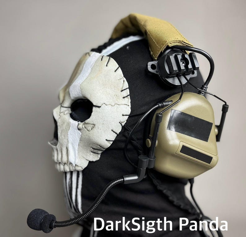May include: A black balaclava with a skull mask and headset. The skull mask is off-white with black stitching and a white stripe. The headset is tan with a black microphone. The text "DarkSigth Panda" is visible.
