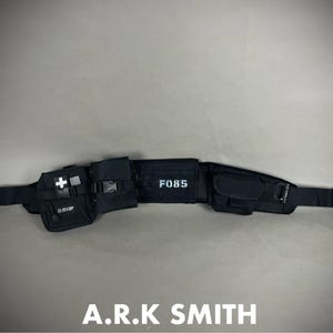 May include: Black tactical belt with multiple pouches and compartments. Features a white cross symbol, the text "F085", and the brand name "A.R.K SMITH". Includes adjustable straps and buckle closures.