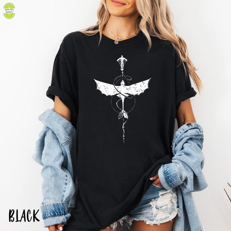 May include: Black t-shirt with a white dragon graphic. The dragon design has detailed wings and tail. The word "BLACK" is printed at the bottom left. The shirt is a casual style, suitable for everyday wear.