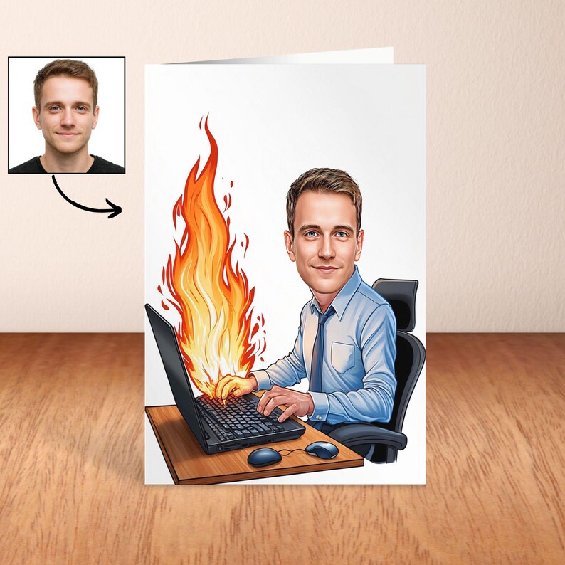 May include: A greeting card featuring a cartoon illustration of a man working on a laptop with flames erupting from it. The man is wearing a blue shirt and tie. A small photo of the man is in the upper left corner. The card is on a wooden surface.