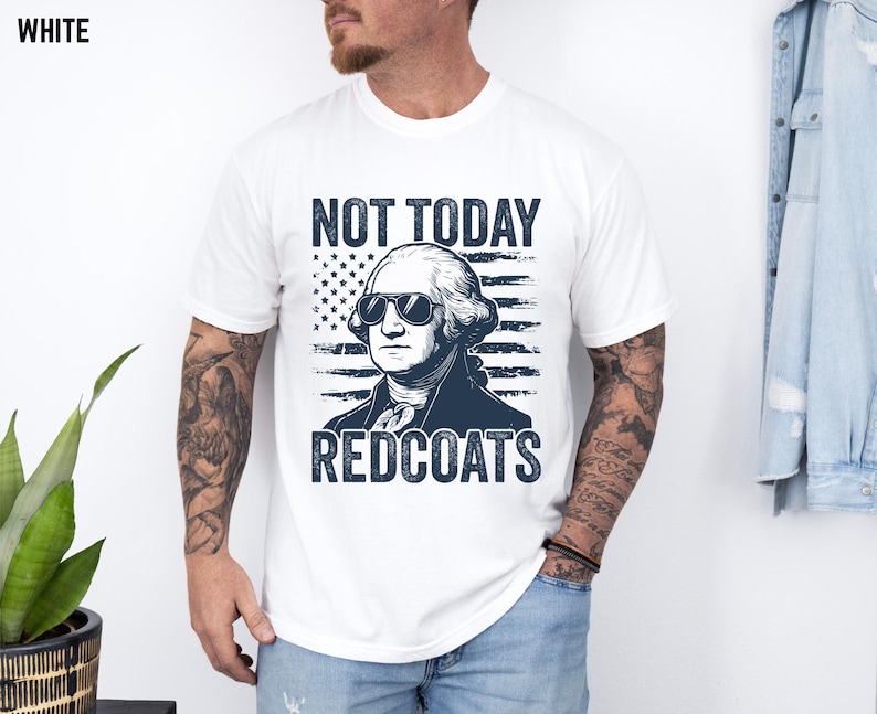 May include: White t-shirt featuring a navy blue graphic of George Washington in sunglasses, with the text "NOT TODAY REDCOATS". The design includes a navy blue American flag background.