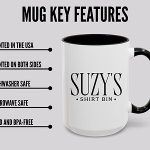 Pu&ograve; includere: Tazza bianca con interno e manico neri. La tazza presenta la scritta "SUZY'S SHIRT BIN" in nero. L'immagine include anche il testo che indica che la tazza &egrave; stampata negli Stati Uniti, stampata su entrambi i lati, lavabile in lavastoviglie e microonde, senza piombo e senza BPA.