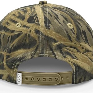 May include: A camouflage baseball cap with a brown adjustable strap and the word "LOST" printed on the side.