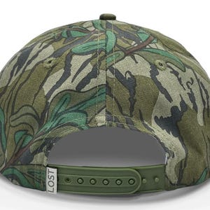 May include: A green, brown, and black camouflage baseball cap with an adjustable strap and the word "LOST" printed on the side.
