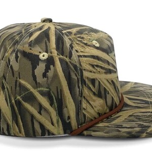 May include: A camouflage baseball cap with a brown leather strap. The cap is made of a soft, durable fabric and features a classic five-panel design.