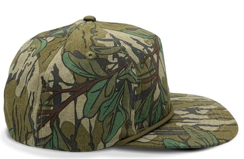 May include: A green and brown camouflage baseball cap with a flat brim.
