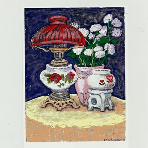 Könnte beinhalten: Ein Stillleben-Gemälde mit einer rot schattierten Lampe, einer Vase mit weißen Blumen und einer kleinen dekorativen Vase mit Herzmuster. Die Lampe hat einen weißen Sockel mit roten Rosendetails. Der Hintergrund ist dunkelblau und der Tisch ist beige.