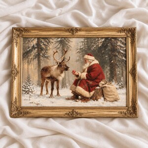 Könnte beinhalten: Ein rechteckiges gerahmtes Gemälde zeigt den Weihnachtsmann in einem rot-weißen Mantel, der auf einem Baumstumpf in einem verschneiten Wald sitzt. Er hält einen kleinen roten Apfel einem Rentier entgegen. Ein beiger Sack liegt neben ihm.