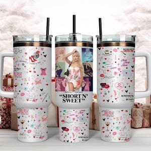 May include: Three white travel mugs with handles, featuring a gold rim and black straw. The mugs are decorated with a collage of images, hearts, lipstick, and text, including "SHORT N' SWEET" and "TASTE ME".