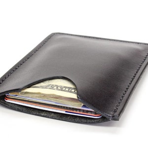 Black leather minimalist wallet on white background.
