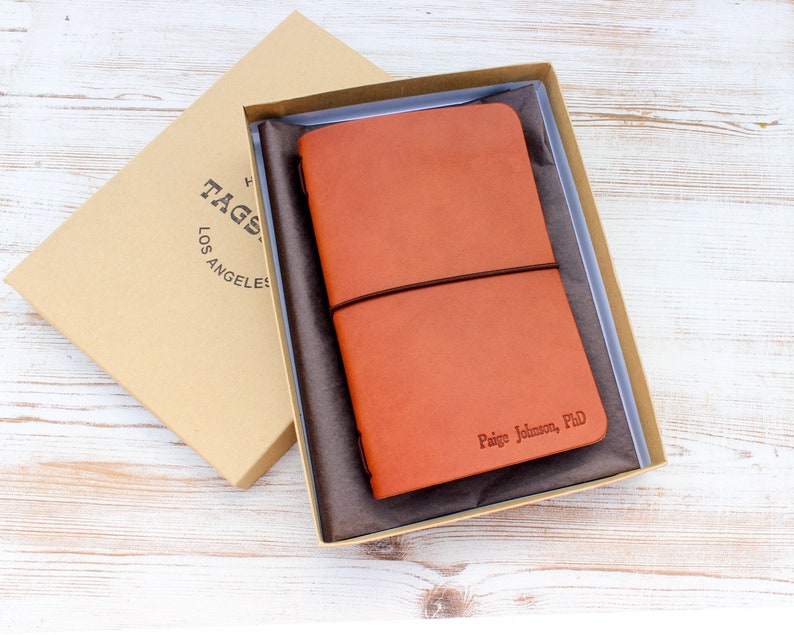 Doctorate graduation gift personalized leather notebook with name and PhD hot stamped into the leather. Cognac colored leather.