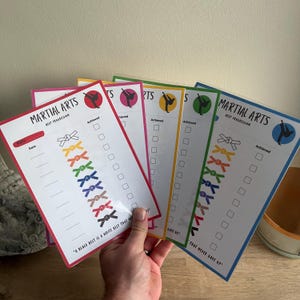 Może przedstawiać: Zestaw trzech ceramicznych kubków z nakrapianym, matowym wykończeniem. Kubki są w odcieniach kremowym, jasnoszarym i ciemnoszarym. Każdy kubek ma prosty, minimalistyczny design, idealny do kawy lub herbaty.