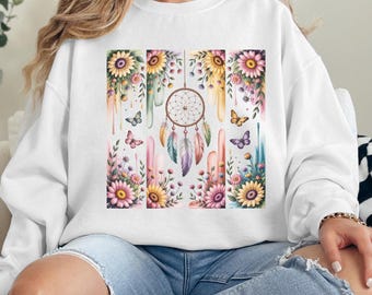 Könnte beinhalten: Ein weißer Pullover mit einem farbenfrohen Blumen- und Traumfänger-Design. Das Design zeigt einen Traumfänger mit Federn, Schmetterlingen und Blumen in den Farben Rosa, Gelb, Blau und Grün.